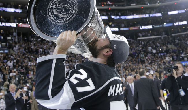Los Angeles Kings defenseman Alec Martinez kisses the Stanley Cup after beating the New York Rangers in Game 5 of the NHL Stanley Cup Final series Friday, June 13, 2014, in Los Angeles. The Kings won, 3-2, with Martinez scoring the winning goal in double overtime. (AP Photo/Jae C. Hong)