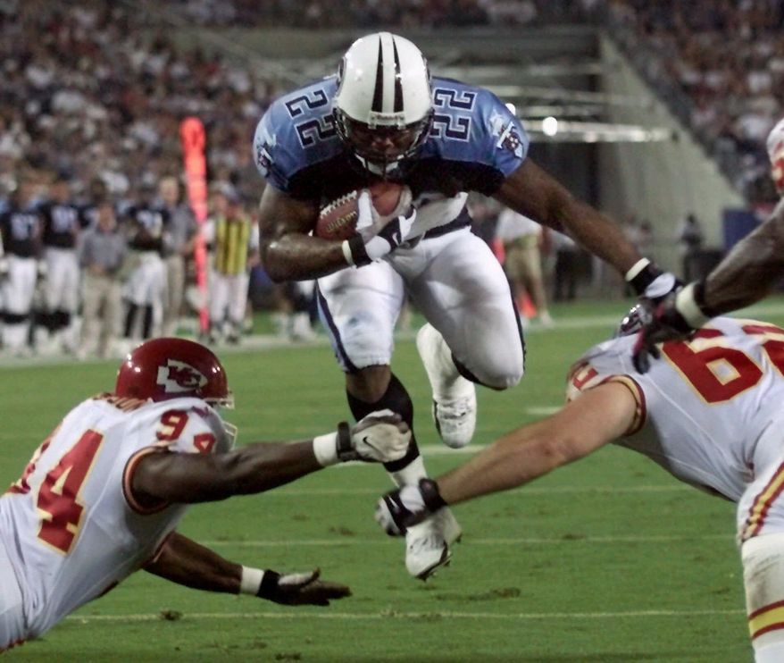 FILE - In this Aug. 5, 2000, file photo, Tennessee Titans running back Rodney Thomas (22) jumps between Kansas City Chiefs defenders Jonathan Jackson (94) and Kevin Sluder (62) to score a touchdown in the second quarter of an NFL football game in Nashville, Tenn. A Texas funeral home director says former Houston Oilers and Titans running back Thomas has died at age 41. Groveton Funeral Home owner Terry Cartwright says Thomas died Saturday, June 14, 2014, of an unknown cause and that an autopsy is underway. (AP Photo/Wade Payne, File)
