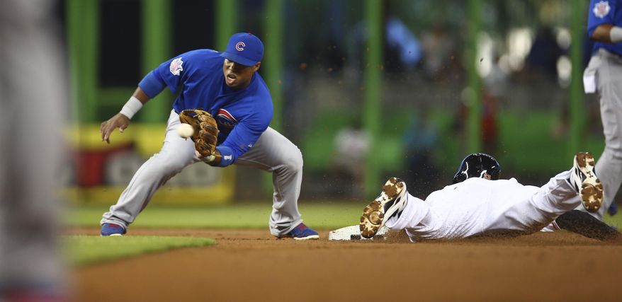 Miami Marlins' Jake Marisnick, right, steals second on a late throw from the Chicago Cubs catcher to second baseman Luis Valbuena, left, during the first inning of a baseball game in Miami, Monday, June 16, 2014. (AP Photo/J Pat Carter)