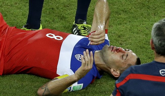 United States' Clint Dempsey lies on the pitch after being kicked in his face during the group G World Cup soccer match between Ghana and the United States at the Arena das Dunas in Natal, Brazil, Monday, June 16, 2014. (AP Photo/Hassan Ammar)