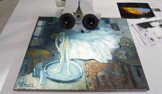 &amp;quot;The Blue Room,&amp;quot; one of Pablo Picasso&#39;s first masterpieces sits under a microscope at The Phillips Collection, on Tuesday, June 10, 2014, in Washington. Scientists and art experts have found a hidden painting beneath the painting. Advances in infrared imagery reveal a bow-tied man with his face resting on his hand, with three rings on his fingers. Now the question that conservators at The Phillips Collection in Washington hope to answer is simply: Who is he? It’s a mystery that’s fueling new research about the 1901 painting created early in Picasso’s career while he was working in Paris at the start of his distinctive blue period of melancholy subjects. (AP Photo/ Evan Vucci)