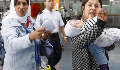 Roma women gesture before being expelled from France at Charles de Gaulle Airport northeast of Paris on Thursday, Aug. 26, 2010. (AP Photo/Jacques Brinon)