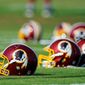 FILE - In this June 17, 2014, file photo, Washington Redskins helmets sit on the field during an NFL football minicamp in Ashburn, Va. The U.S. Patent Office ruled Wednesday, June 18, 2014, that the Washington Redskins nickname is &quot;disparaging of Native Americans&quot; and that the team&#39;s federal trademarks for the name must be canceled. The ruling comes after a campaign to change the name has gained momentum over the past year. (AP Photo/Nick Wass, File)