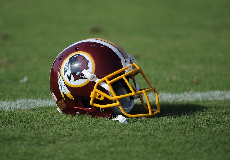 A Washington Redskins football helmet lies on the field during NFL football minicamp, Wednesday, June 18, 2014, in Ashburn, Va. The U.S. Patent Office ruled Wednesday, June 18, 2014, that the Washington Redskins nickname is "disparaging of Native Americans" and that the team's federal trademarks for the name must be canceled. The ruling comes after a campaign to change the name has gained momentum over the past year. (AP Photo/Nick Wass)