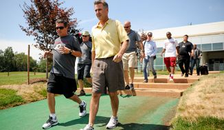 Washington Redskins owner Dan Snyder, left, and general manager Bruce Allen, center, make their way out to practice at Redskins Park, Ashburn, Va., Wednesday, August 21, 2013. (Andrew Harnik/The Washington Times)