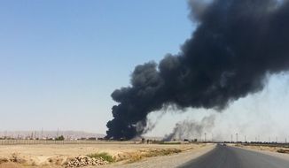 A column of smoke rises from an oil refinery in Baiji, 155 miles north of Baghdad, on Thursday. Sunni Muslim extremists who have taken over large portions of northern Iraq have shown their willingness to use oil supplies as a weapon. (Associated Press)