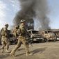 U.S. soldiers investigate the scene of an suicide attack in the Torkham, Nangarhar province, Afghanistan, on June 19. Afghan officials say three Taliban suicide bombers targeted NATO fuel trucks at the border with Pakistan, setting off a gunbattle with police guards. (Associated Press)