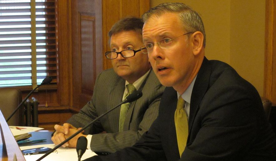**FILE** Kansas House Minority Leader Paul Davis, right, a Lawrence Democrat, asks questions about plans to shift $675 million among various government accounts so that the state can pay its bills on time over the next year, Thursday, June 19, 2014, at the Statehouse in Topeka, Kan. Gov. Sam Brownback and legislative leaders, including Davis, have signed off on those plans. (AP Photo/John Hanna)