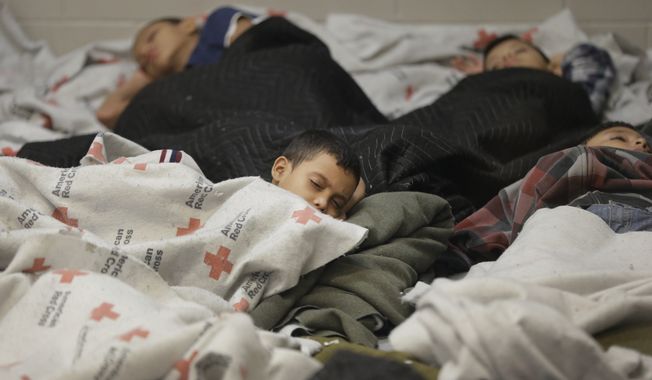 Children are held at a U.S. Customs and Border Protection processing facility in Brownsville, Texas. Thousands of children crossing alone into the U.S. can live in American cities, attend public schools and possibly work for years without consequences. (Associated Press)