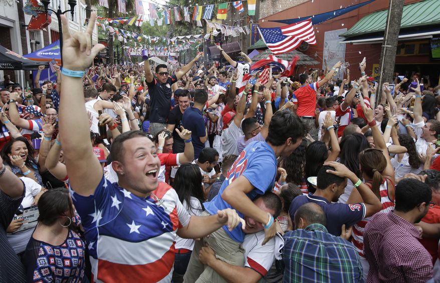 Fans cheer after the United States scored a goal against Portugal as they watch a World Cup soccer match on a big screen television Sunday, June 22, 2014, in Orlando, Fla. (AP Photo/John Raoux)