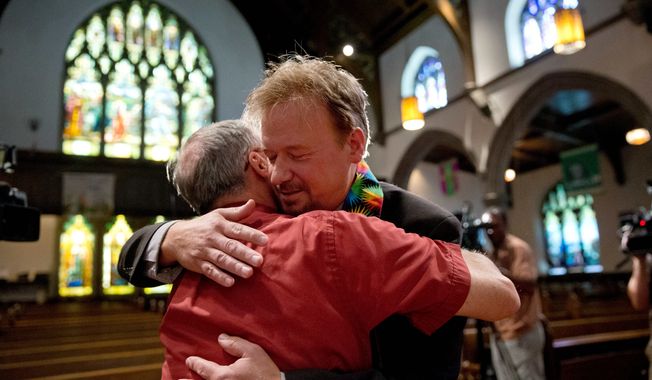 United Methodist pastor Frank Schaefer, right, hugs the Rev. David Wesley Brown after a news conference Tuesday, June 24, 2014, at First United Methodist Church of Germantown in Philadelphia. Schaefer, who presided over his son&#x27;s same-sex wedding ceremony and vowed to perform other gay marriages if asked, can return to the pulpit after a United Methodist Church appeals panel on Tuesday overturned a decision to defrock him. (AP Photo/Matt Rourke)