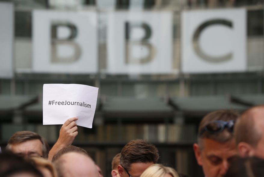 BBC journalists and staff, hold a minute of silence in support of the jailed journalists in Egypt, exactly 24 hours after their sentencing, outside the BBC headquarters in central London, Tuesday, June 24, 2014. An Egyptian court on Monday convicted three journalists from Al-Jazeera English and sentenced them to seven years in prison each on terrorism-related charges, bringing widespread criticism that the verdict was a blow to freedom of expression. The three, Australian Peter Greste, Canadian-Egyptian Mohamed Fahmy and Egyptian Baher Mohammed, have been detained since December charged with supporting the Muslim Brotherhood, which has been declared a terrorist organization, and of fabricating footage to undermine Egypt's national security and make it appear the country was facing civil war. (AP Photo/Lefteris Pitarakis)