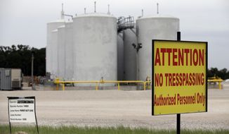 Signs warn against trespassing at a well injection site operated by Bridgeport Tank Trucks LTD., Saturday, June 21, 2014, in Azle, Texas. Earthquakes used to be unheard of on the vast stretches of prairie that unroll across Texas and Oklahoma.  But in recent years, temblors have become commonplace. Oklahoma recorded 145 of them just between January and the start of May. (AP Photo/Tony Gutierrez)