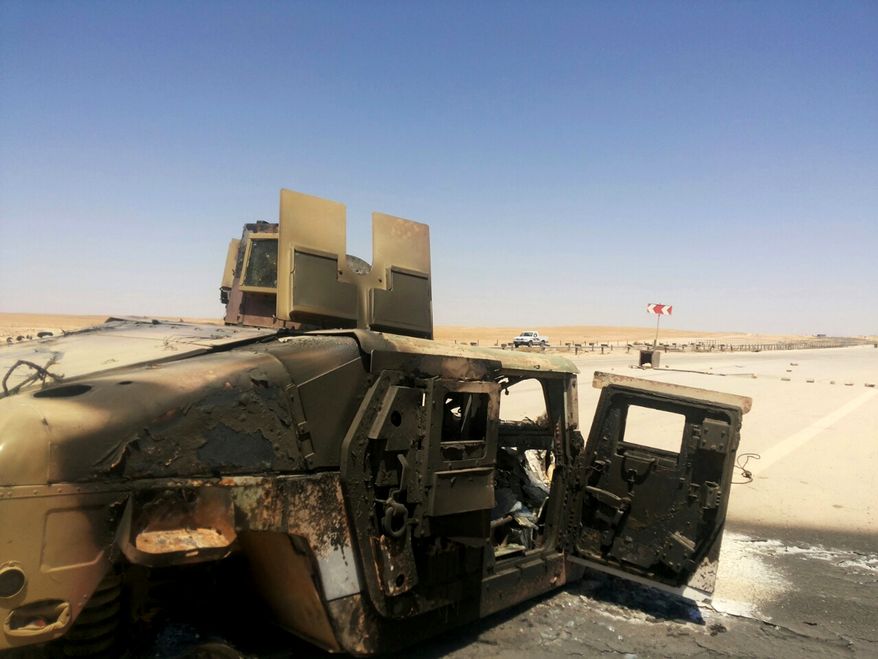 A destroyed Iraqi army humvee is left behind outside of the northern city of Mosul, Iraq, Wednesday, June 25, 2014, more than two weeks after the al-Qaida-inspired Islamic Sate of Iraq and the Levant (ISIL) took over the country's second largest city. U.S. Secretary of State John Kerry warned Mideast nations on Wednesday against taking new military action in Iraq that might heighten already-tense sectarian divisions, as reports surfaced that Syria launched airstrikes across the border and Iran has been flying surveillance drones over the neighboring country. (AP Photo)