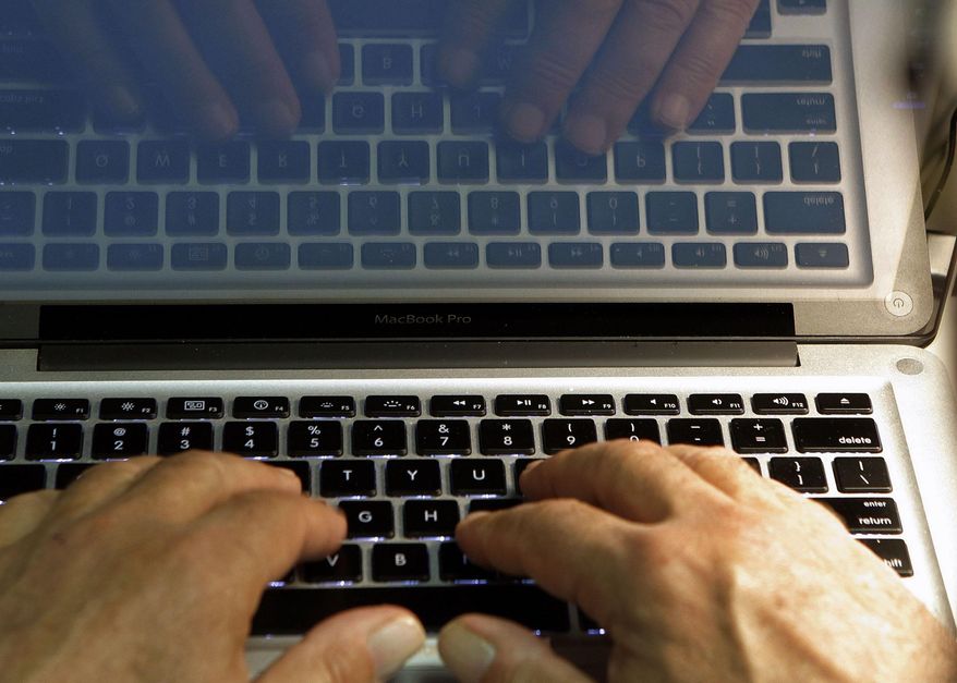 In this Feb. 27, 2013, photo illustration, hands type on a computer keyboard in Los Angeles. (AP Photo/Damian Dovarganes, File)