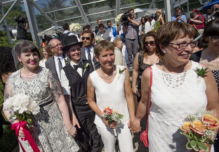 Newlyweds celebrate after over 100 gay couples participated in a mass wedding during World Pride 2014 at Casa Loma in Toronto, Thursday, June 26, 2014. (AP Photo/The Canadian Press, Darren Calabrese)