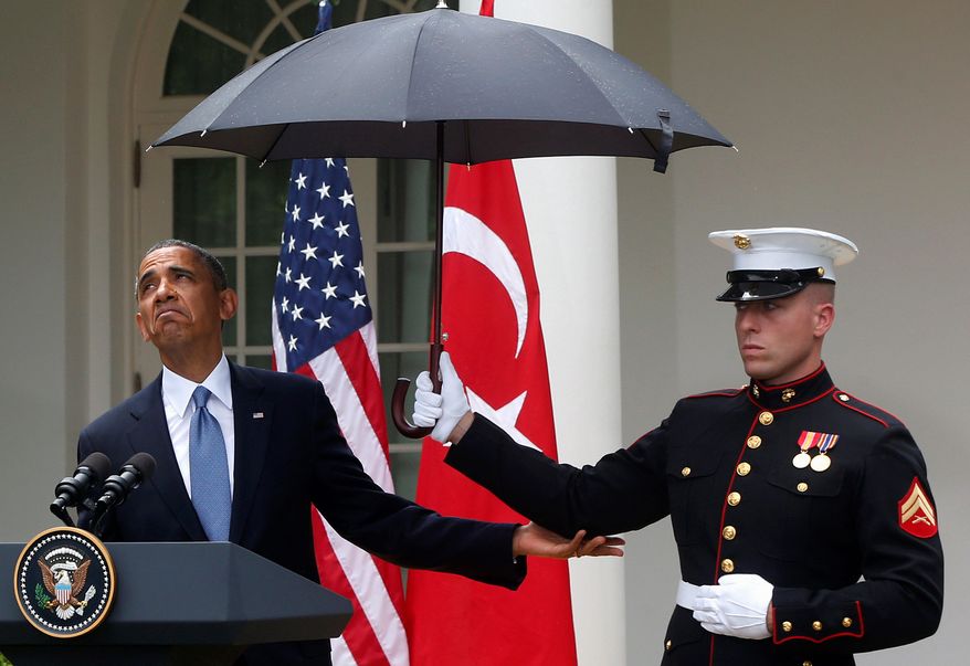 Pay no attention to the umbrella: President Obama says sunny days are here again. (Associated Press)