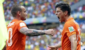 Netherlands&#x27; Klaas-Jan Huntelaar, right, celebrates with Wesley Sneijder after scoring his side&#x27;s second goal during the World Cup round of 16 soccer match between the Netherlands and Mexico at the Arena Castelao in Fortaleza, Brazil, Sunday, June 29, 2014. The Netherlands won the match 2-1. (AP Photo/Natacha Pisarenko)