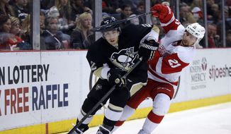 Detroit Red Wings&#39; Tomas Tatar (21), of Slovakia, tries to get to the puck controlled by Pittsburgh Penguins&#39; Matt Niskanen (2) during the second period of an NHL hockey game Thursday, March 20, 2014 in Detroit. The Red Wings defeated the Penguins 5-4 in overtime. (AP Photo/Duane Burleson)