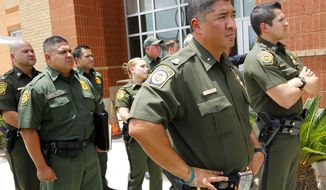 **FILE** U.S. Border Patrol Agents listen to U.S. Secretary of Homeland Security Jeh Johnson speak during a press conference in Edinburg, Texas, on June 30, 2014. Johnson said he is sending an additional 150 Border Patrol agents to the Rio Grande Valley Sector to help with a recent spike in immigrants crossing the border through the area. (Associated Press/The Monitor, Nathan Lambrecht)