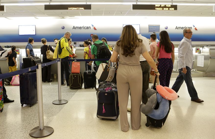 In this photo taken Wednesday, June 25, 2014, passengers wait in line at the American Airlines International counter at Miami International Airport in Miami. American Airlines announced that it will cut nearly 80 percent of its flights to Venezuela in a dispute over revenue being held by the South American country. American said that beginning July 2 it will operate 10 flights per week instead of the current 48. And it will only fly to Venezuela from Miami, scrapping flights from New York, Dallas and San Juan, Puerto Rico. (AP Photo/Alan Diaz)