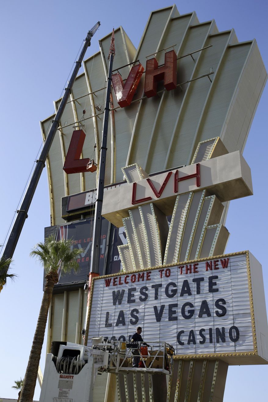 Construction workers lower part of the LVH sign Tuesday, July 1, 2014 in Las Vegas. Florida-based timeshare company Westgate Resorts announced it purchased the LVH hotel from Goldman Sachs and Gramercy Capital and would rename it Westgate Las Vegas Resort & Casino. Some of the nearly 3,000 rooms and suites will be converted to timeshare villas, while others will remain open to regular hotel guests. (AP Photo/John Locher)