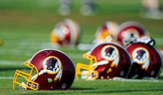 FILE - In this June 17, 2014, file photo, Washington Redskins helmets sit on the field during an NFL football minicamp in Ashburn, Va. The U.S. Patent Office ruled Wednesday, June 18, 2014, that the Washington Redskins nickname is &quot;disparaging of Native Americans&quot; and that the team&#x27;s federal trademarks for the name must be canceled. The ruling comes after a campaign to change the name has gained momentum over the past year. (AP Photo/Nick Wass, File)