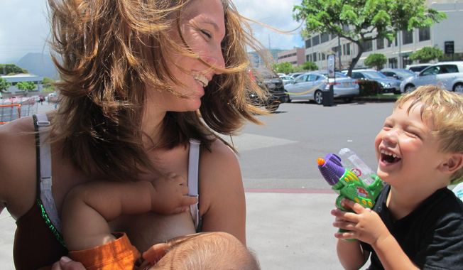 Karen Penley breastfeeds her son Nakana while talking to her older son Zayden in Honolulu on Tuesday, July 1, 2014. A Honolulu homeless shelter won&#x27;t take action against a mother who is refusing to cover up while breastfeeding or use a private room. (AP Photo/Audrey McAvoy)
