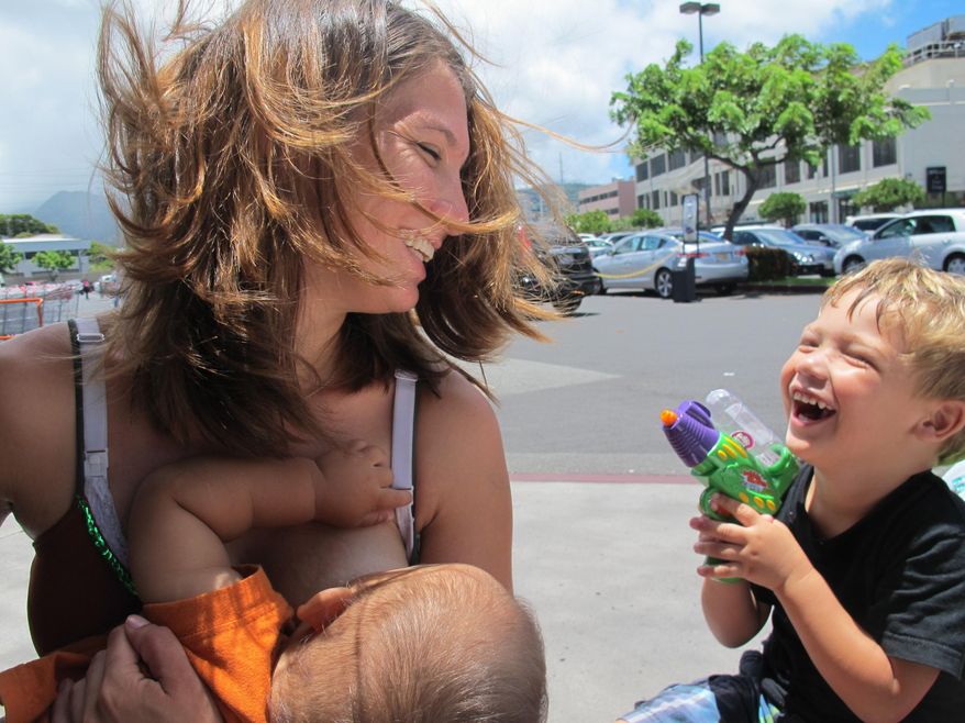 Karen Penley breastfeeds her son Nakana while talking to her older son Zayden in Honolulu on Tuesday, July 1, 2014. A Honolulu homeless shelter won&#x27;t take action against a mother who is refusing to cover up while breastfeeding or use a private room. (AP Photo/Audrey McAvoy)