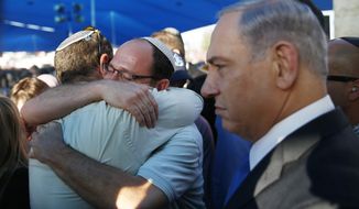 Israeli Prime Minister Benjamin Netanyahu, right, stands next to Avi Fraenkel, left, and Ori Yifrah, fathers of two of the three Israeli teens who were abducted and killed in the West Bank as they hug during their sons&#39; joint funeral in the Israeli city of Modiin, Tuesday, July 1, 2014. Tens of thousands of mourners converged Tuesday in central Israel for the funeral service for three teenagers found dead in the West Bank after a two week search and crackdown on the Hamas militant group, which Israeli leaders have accused of abducting and killing the young men. The deaths of Eyal Yifrah, 19, Gilad Shaar, 16, and Naftali Fraenkel, a 16-year-old with dual Israeli-American citizenship, have prompted angry calls for revenge and Prime Minister Benjamin Netanyahu convened his security Cabinet for an emergency meeting to discuss a response to the killings, hours after airstrikes targeted dozens of suspected Hamas positions in the Gaza Strip.(AP Photo/Baz Ratner, Pool)
