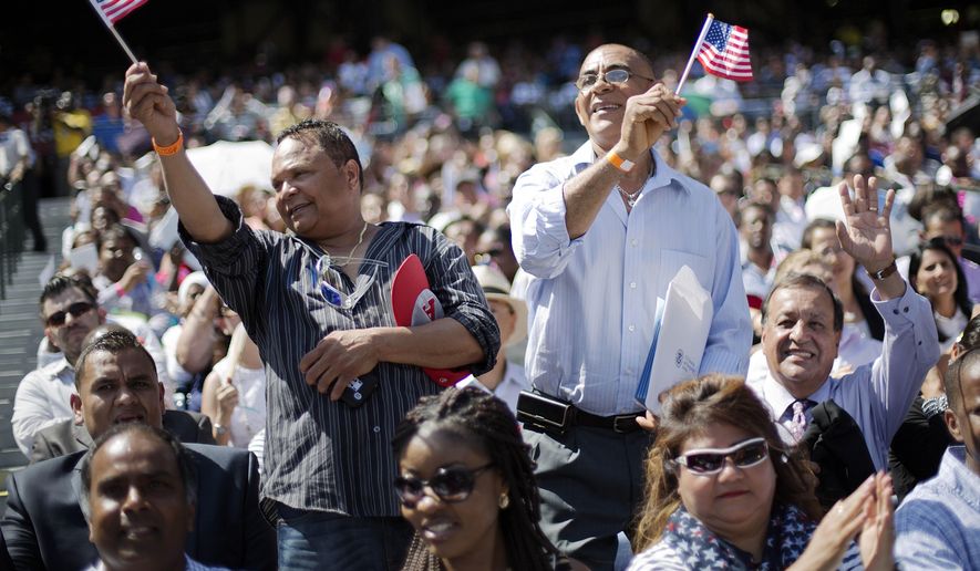 Hector Colon, left, and Victor Duran, right, both of the Dominican Republic, wave American flags after being sworn in during a naturalization ceremony for more than 1,000 citizenship candidates at Turner Field, home of the Atlanta Braves baseball team, Wednesday, July 2, 2014, in Atlanta. (AP Photo/David Goldman) ** FILE **