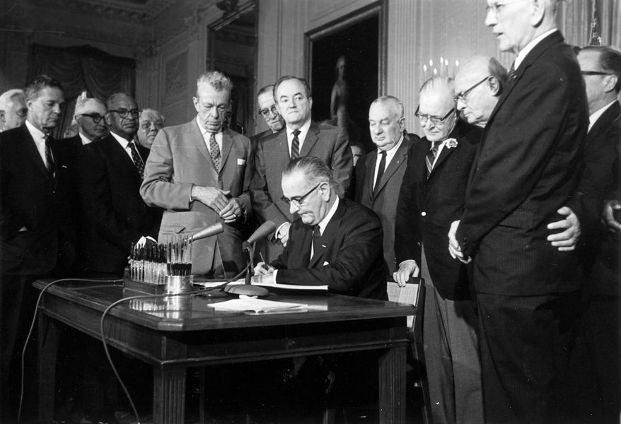 President Lyndon Johnson signing the 1964 Civil Rights Act at the White House with key Senate allies Everett Dirksen (R-Ill.), standing at left, and Hubert Humphrey (D-Minn.), standing behind Johnson. (AP Photo, File)