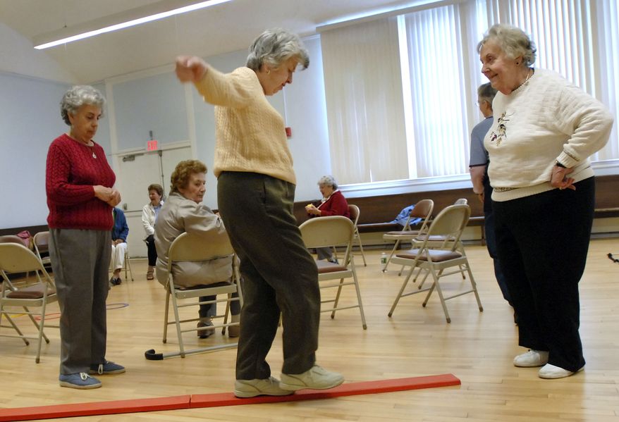 **FILE** Shirley Ristau (right) coaches Johanna O'Neill (center) through a balance obstacle course while O'Neill's sister, Mary O'Neill (left), looks on during a fall prevention demonstration class at the Manchester Senior Center in Manchester, Conn., on April 25, 2007. As deaths from fall-related injuries have skyrocketed nationwide, officials from several states, universities and hospitals are doing more help elderly people avoid falling. (Associated Press)