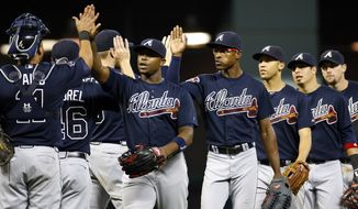 Atlanta Braves&#39; Justin Upton, center left, and his brother B.J. Upton, center right, celebrate with teammates after the Braves defeated the Houston Astros 3-2 in a baseball game Tuesday, June 24, 2014, in Houston. (AP Photo/David J. Phillip)