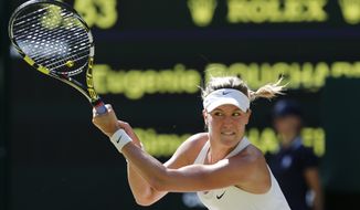 Eugenie Bouchard of Canada plays a return to Simona Halep of Romania during their women&amp;#8217;s singles semifinal match at the All England Lawn Tennis Championships in Wimbledon, London, Thursday, July 3, 2014. (AP Photo/Ben Curtis)