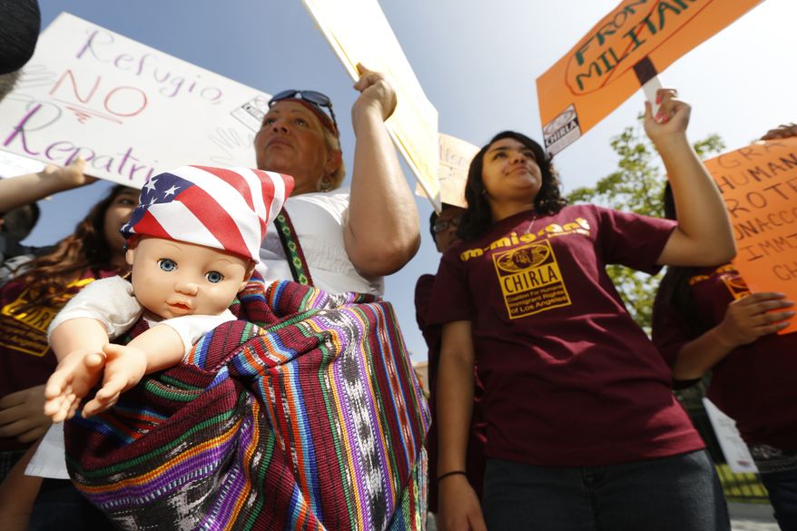 Immigration activists Amarily Ortiz, left, and Mayra Sixtos, demand the Mexican government to take more measures to protect and respect the rights of unaccompanied minors and families crossing Mexico's territory during a protest outside the Mexican Consulate in Los Angeles Thursday, July 3, 2014. Activists demand support of migrant children and families Thursday, two days after U.S. Homeland Security buses carrying the migrants were routed away from American flag-waving protesters in Murrieta, Calif., and transported to a facility in San Diego. (AP Photo/Damian Dovarganes)