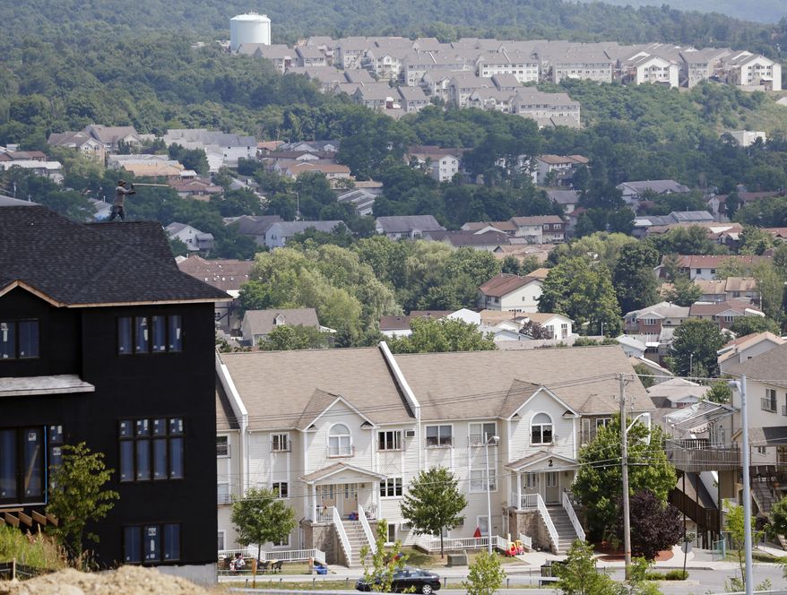 A new housing unit, left, is under construction on Tuesday, July 1, 2014, in Kiryas Joel, N.Y. (AP Photo/Mike Groll)