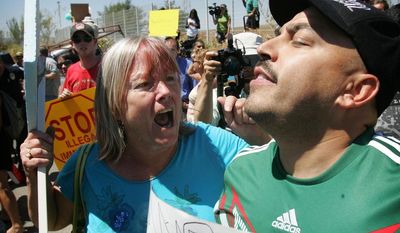 An unidentified protester, left, argues with American citizen Lupillo Rivera, brother of Mexican-American singer Jenni Rivera, right, as three buses carrying 140 immigrants attempt to enter the Murrieta U.S. Border Patrol station for processing on Tuesday, July 1, 2014.  (AP Photo/The Press-Enterprise, )  MAGS OUT; MANDATORY CREDIT