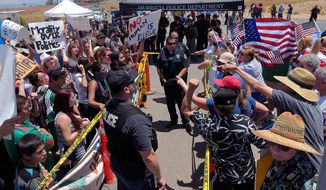 Demonstrators on opposing sides of the immigration debate are separated by police officers Friday outside a U.S. Border Patrol station in Murrieta, California. The town was the latest flashpoint for standoffs over the transport of illegal minor immigrants.  (Associated Press)