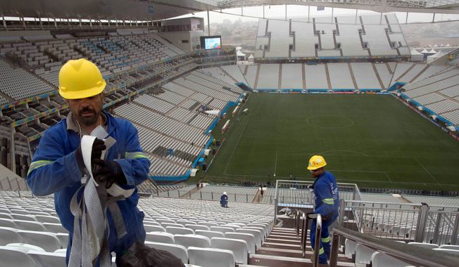 Workers clean the stairs at Arena Corinthians in Sao Paulo. Brazil faces a shortage of up to 8.5 million workers in 2020 if it hopes to maintain current growth rates, according to a report from the Boston Consulting Group. The United States is forecast to have a surplus of up to 22 million workers in 2020. (Associated Press)