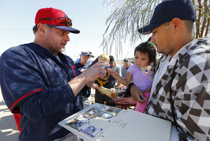 Cleveland Indians' Jason Giambi signs autographs for fans during spring training baseball practice in Goodyear, Ariz., Monday, Feb. 17, 2014. (AP Photo/Paul Sancya)