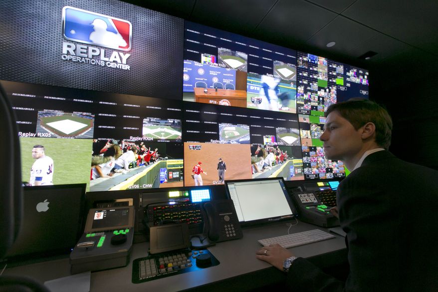 Chris Marinak sits in front of a bank of television screens during a preview of Major League Baseball's Replay Operations Center, in New York, Wednesday, March 26, 2014. (AP Photo/Richard Drew)