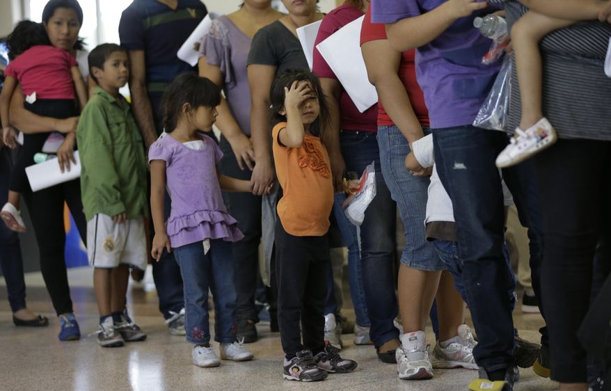 FILE - In this June 20, 2014 file photo, immigrants who entered the U.S. illegally stand in line for tickets at the bus station after they were released from a U.S. Customs and Border Protection processing facility in McAllen, Texas. Tackling what he has called a humanitarian crisis, President Barack Obama on Tuesday, July 8, 2014 asked Congress for $3.7 billion to cope with a tide of minors from Central America who are illegally crossing the U.S. border, straining immigration resources and causing a political firestorm in Washington. (AP Photo/Eric Gay, File)