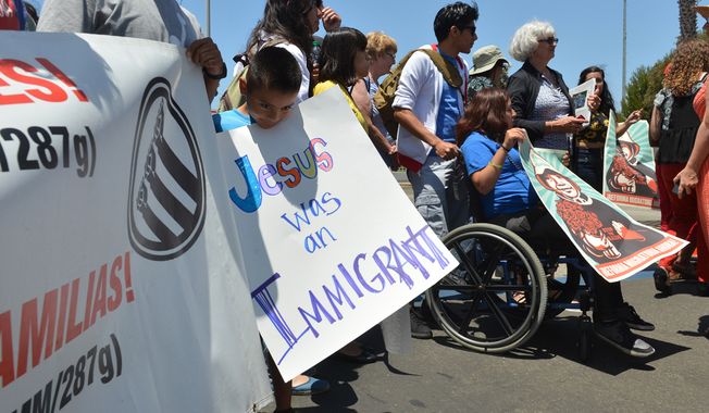 Ernesto Vasquez stands with his father in a demonstration in support of humane treatment of immigrant children who are being temporarily housed at a naval base in Port Hueneme, Calif., on Tuesday, July 8, 2014. California lawmakers and religious leaders say they are pleased with the conditions of a temporary shelter for children caught crossing the border, but they&#x27;re worried about the young immigrants&#x27; future. (AP Photo/Ventura County Star, Karen Quincy Loberg)
