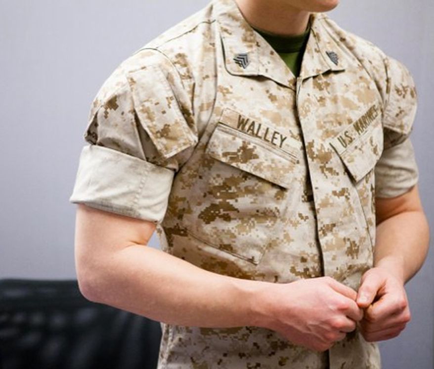 ** FILE ** Pfc. Austin Braun talks to a reporter about rolling sleeves March 10, 2014. When marines transitioned to their desert cammies for warmer weather. (U.S. Army)