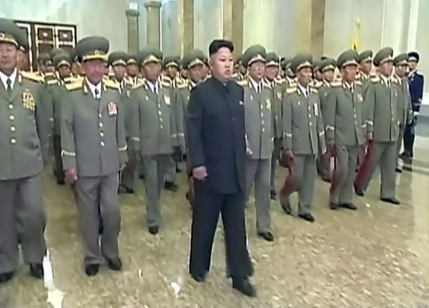 In this Tuesday, July 8, 2014 image made from video, North Korean leader Kim Jong Un, center, visits Kumsusan Palace of the Sun to mark the 20th anniversary of the death of its first leader, Kim Il Sung, in Pyongyang, North Korea. Kim seemed to have somehow hurt his leg enough to require a slight, but visible, limp as he marched across the stage Tuesday to assume his position of honor. He limped again as he left the room when the event was over. (AP Photo/KRT via AP Video) TV OUT, NORTH KOREA OUT