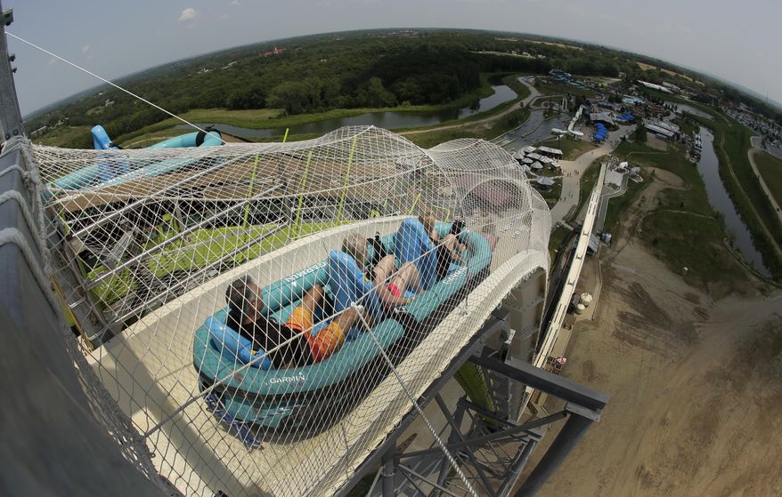 In this photo taken with the fisheye lens, riders go down the world's tallest water slide called "Verruckt" at Schlitterbahn Waterpark, Wednesday, July 9, 2014, in Kansas City, Kan. (AP Photo/Charlie Riedel) ** FILE **
