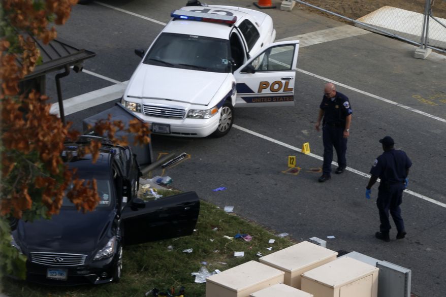 FILE - This Oct. 3, 2013 file photo shows Capitol Hill police officers looking at a car following a car chase and shooting on Capitol Hill in Washington. Miriam Carey was shot to death after the chase that went from the White House to near the Capitol. The attorney for Carey's family says her autopsy finds that she was shot multiple times from behind, including a shot to the back of the head. The Justice Department has declined to bring criminal charges against officers involved in the fatal shooting of a Connecticut woman outside the U.S. Capitol last fall. Prosecutors said Thursday that their months-long investigation into the October shooting of Miriam Carey concluded that officers from the Secret Service and Capitol Police did not use excessive force. (AP Photo/Charles Dharapak, File)