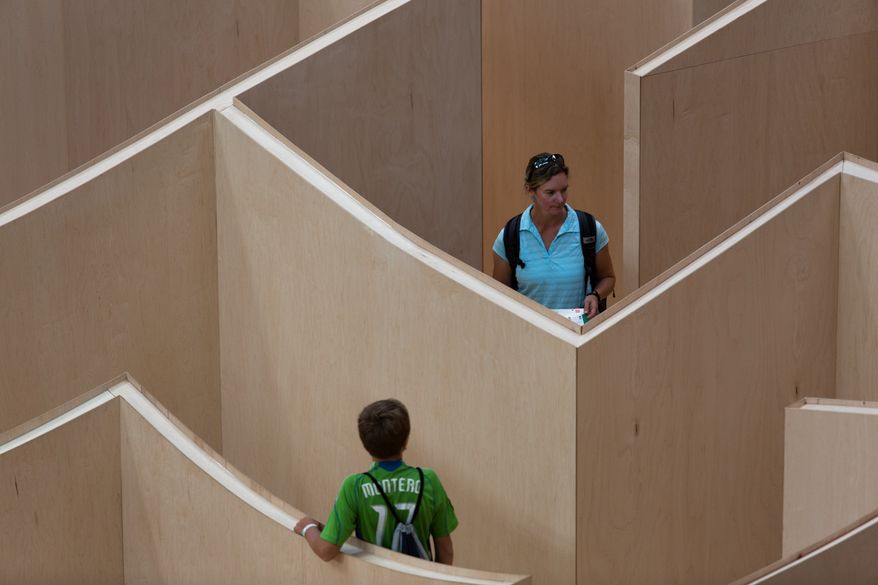 Visitors to the National Building Museum walk through the large-scale Big Maze Thursday morning. The maze was inspired by the ancient history of mazes and will be open to the public until September, 1. Keith Lane/Special to the Washington Times
