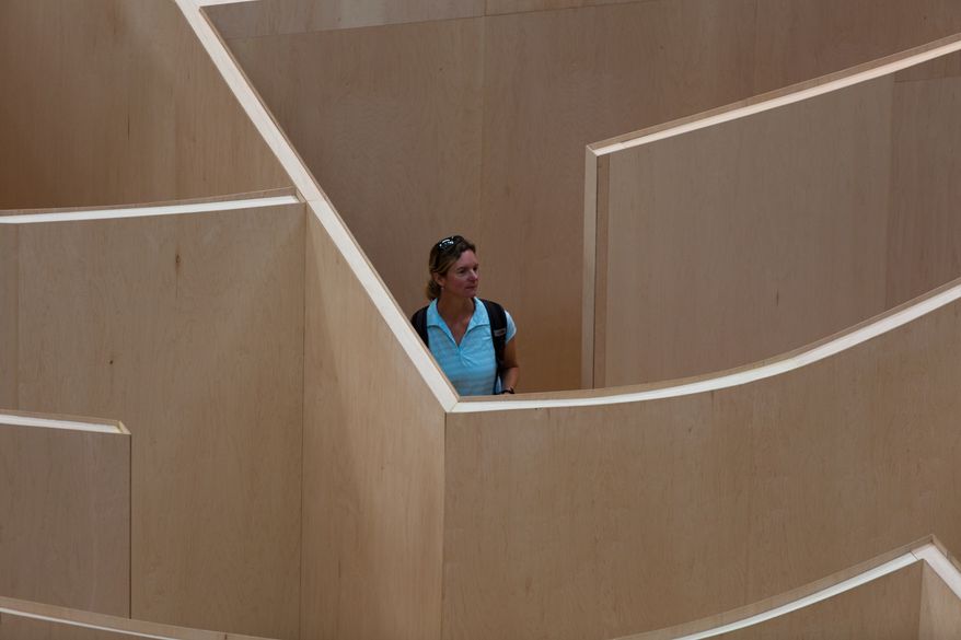 Visitors to the National Building Museum walk through the large-scale Big Maze Thursday morning. The maze was inspired by the ancient history of mazes and will be open to the public until September, 1. Keith Lane/Special to the Washington Times